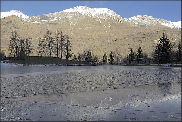 Laux Lake at the entrance to the village of Laux with the village of Usseax in front