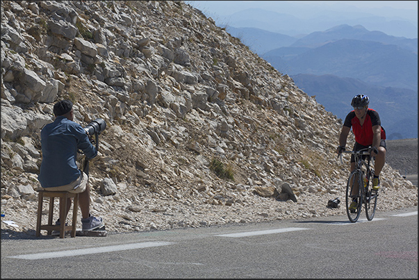 The arrival on the top of the mountain immortalized by the photographer who follows the cyclists