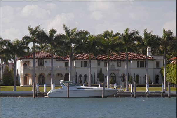 One of the many villas that overlook the lagoon in front of the skyscrapers in the district of Miami Beach One of the many villas that overlook the lagoon in front of the skyscrapers in the district of Miami Beach