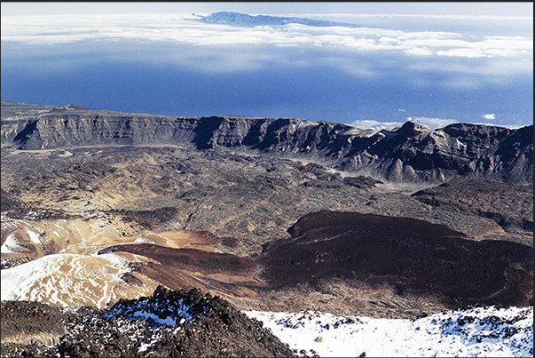 La Canadas del Teide the plateau at the base of Pico del Teide framed by rocky walls. On the horizon Gomera Island