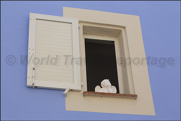 A small ceramic angel adorns a window in the ancient village