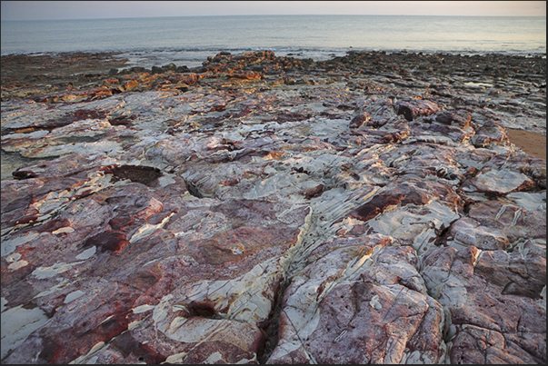 Cox Peninsula (west side of Darwin Bay). The sunset light highlights the red veins (oxidation of iron) present in the white rocks