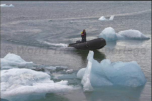 Rangers of the National Park between iceberg on the lake formed by Jokulsarlon Glacier