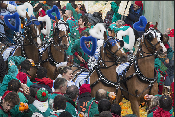 The horses pass quiets in the crowd while behind them there is the battle