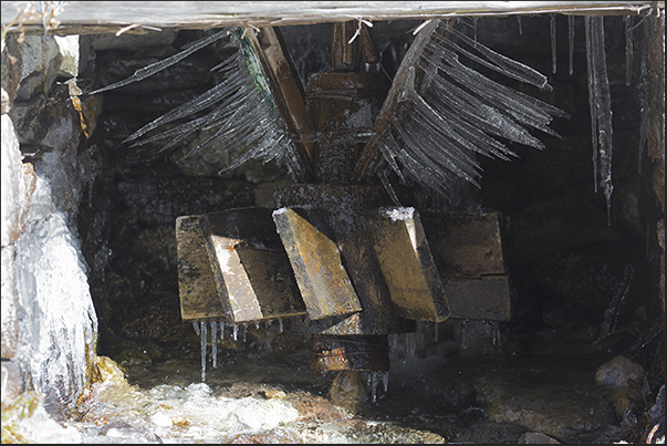 On the blades of a water mill, you see the splash of water transformed in ice overnight