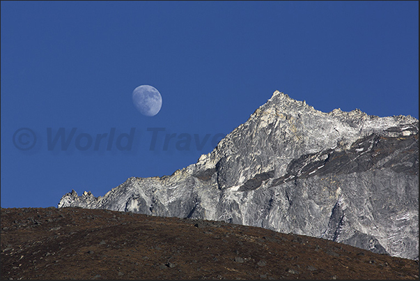 The moon rises while the mountain Amphu Gyabjen (5630 m) is still illuminated by the sun