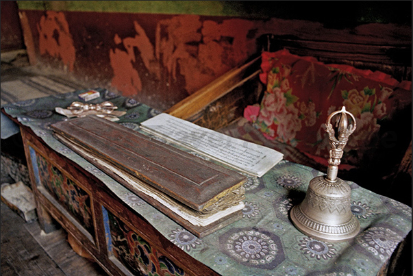 Lamayuru Monastery. Sacred Texts of Buddhism with a bell on the table to indicate to the monks the time and rhythm of prayer Lamayuru Monastery. Sacred Texts of Buddhism with a bell on the table to indicate to the monks the time and rhythm of prayer